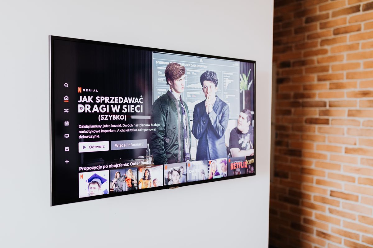Smart TV mounted in a modern living room with a brick wall