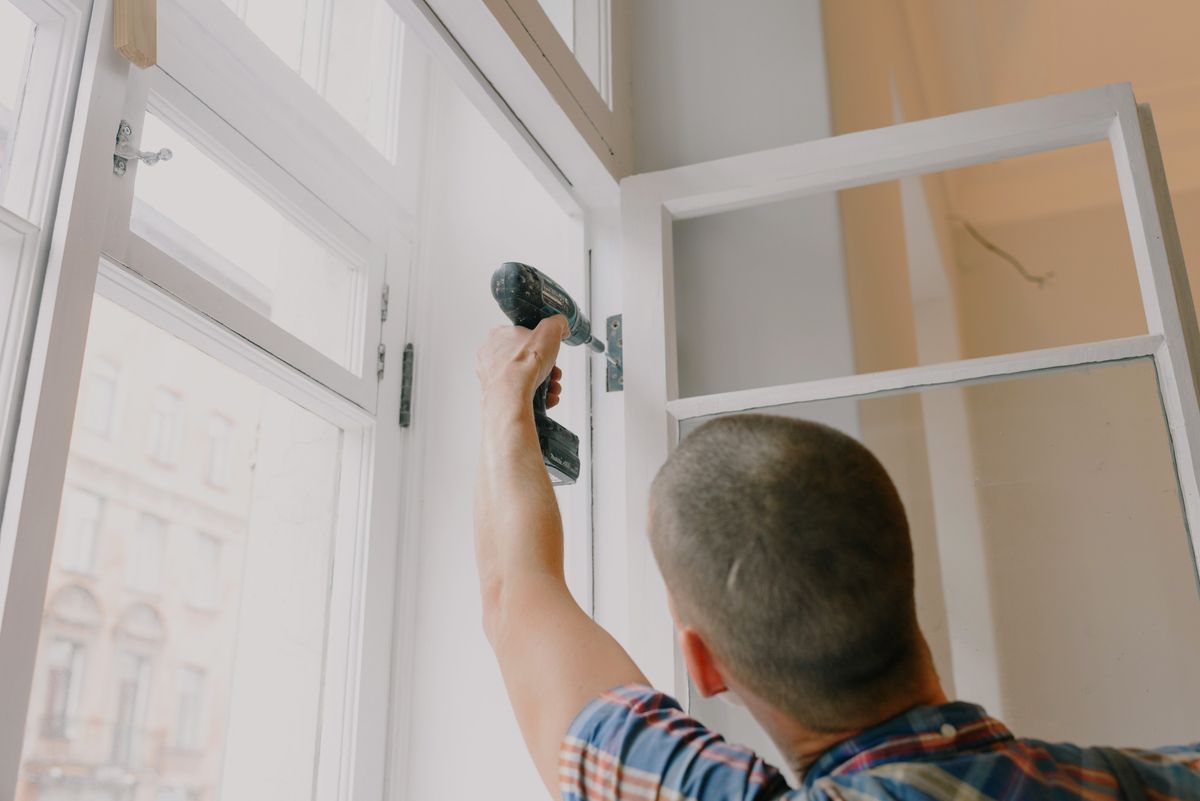 Craftsman assembling a window frame with a cordless screwdriver