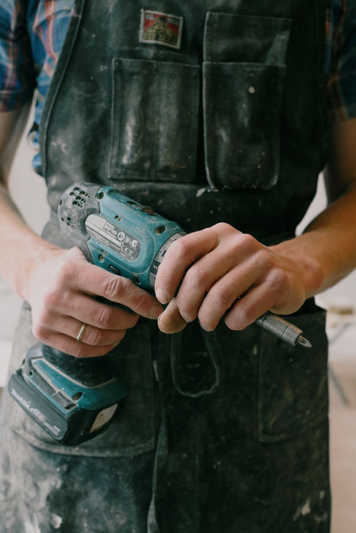 Handyman with a cordless drill doing repair work in a home