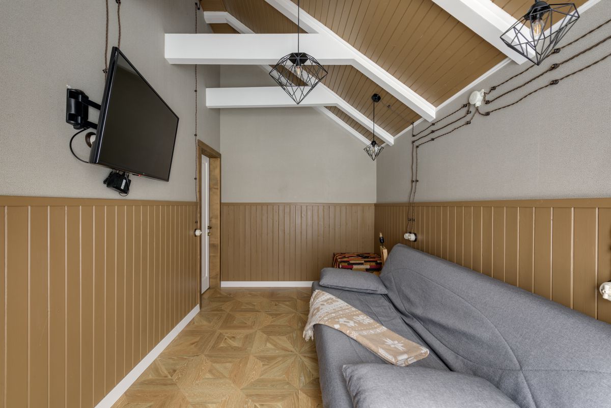 Attic room with a wall-mounted TV and sofa